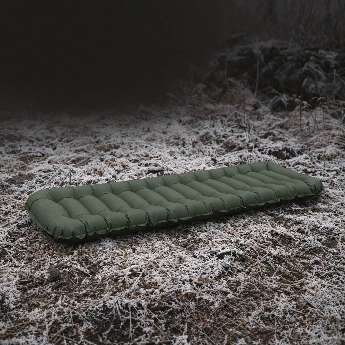 An air pad lying on frosted bare ground, cold rising from below